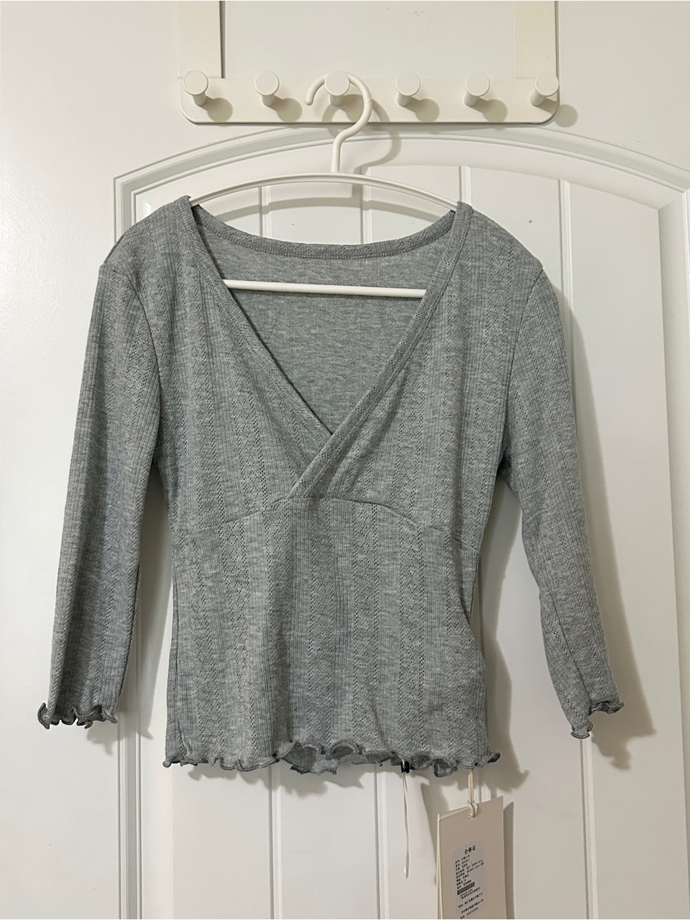 Grey 3/4 sleeve top with ruffle hem and V-neckline